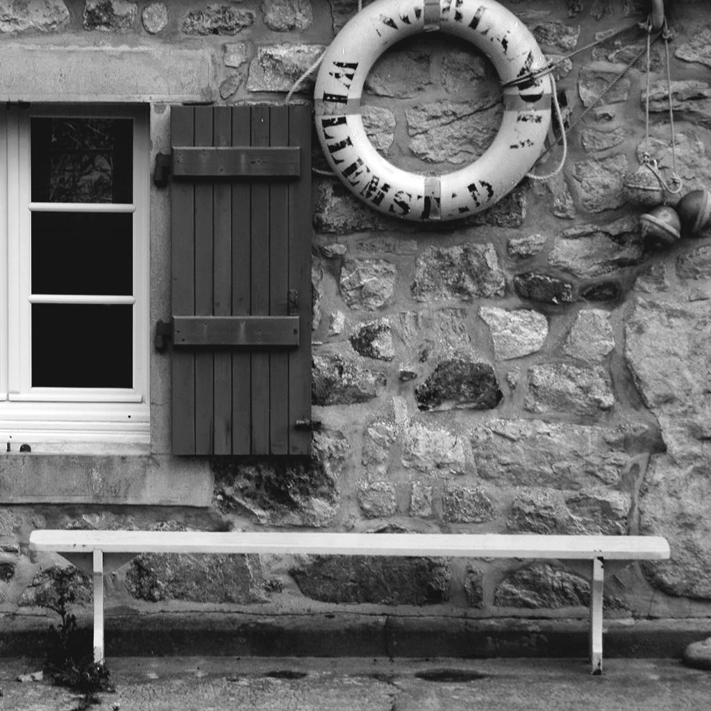 Bank vor einem Haus, Rettungsring an der Wand