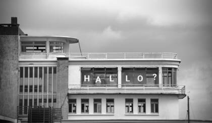 Verlassenes Gebäude am Hafen. Schriftzug in den Fenstern: Hallo?